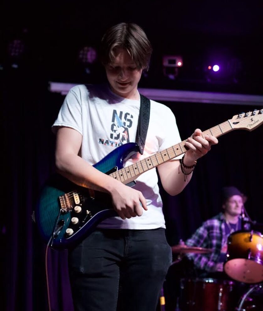 A picture of kai urbany player guitar with ballpark the band at the coast